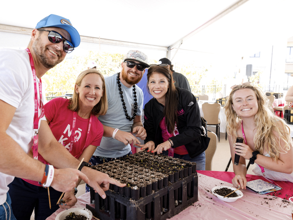 Photo of 5 T-Mobile PEAK guests planting plants and smiling at camera