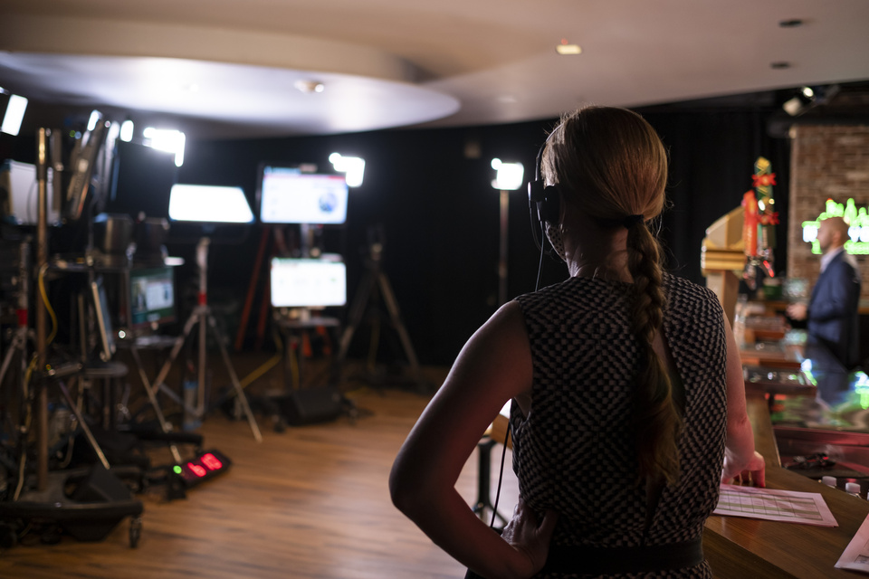 Photo from behind a staff member overlooking the lighting equipment and staged bar set at a Heineken show.