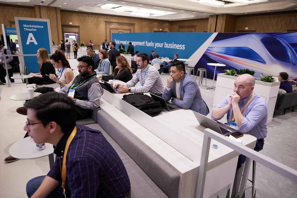 Photo of 10 event attendees paying attention to something out of frame at a conference.