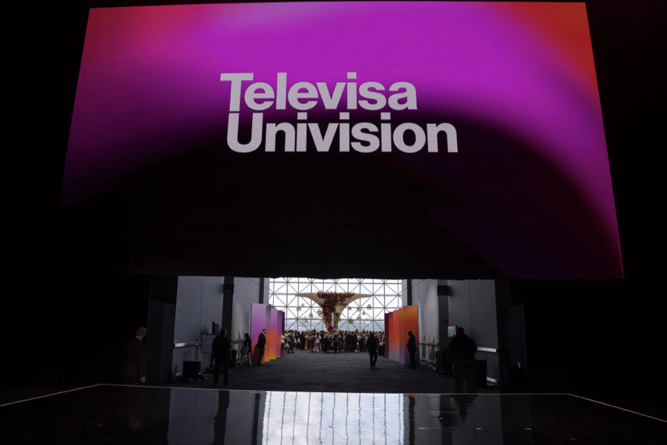 Photo of stage with LED screen reading Televisa Univision pulling up to reveal reception area